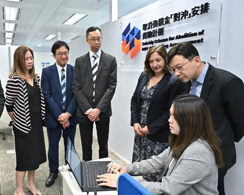 取消強積金「對沖」安排今日生效。圖示取消強積金「對沖」安排資助計劃服務處職員向孫玉菡（右二）及勞工處副處長何錦標（左二）示範僱主如何透過一站式網上平台援「沖」易完成遞交資助申請。