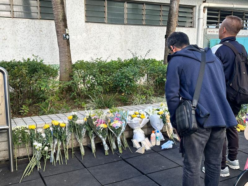 市民到宏福苑側的公園鞠躬獻花，悼念五級大火罹難者。