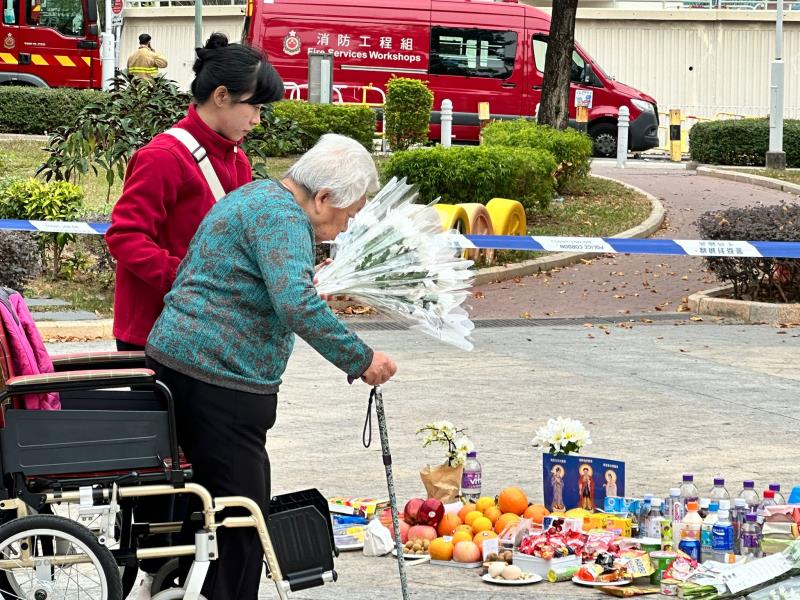 羅婆婆(前)坐輪椅、撐枴杖到宏福苑休息處獻花獻祭品, 願在烈火中逝去的幾位朋友，安心上路。