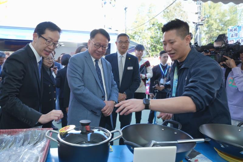 陳國基(中)在盧金榮(左)培同下，參觀工展會並購物，逗留約半小時共洗費超過3800元。廠商會圖片。