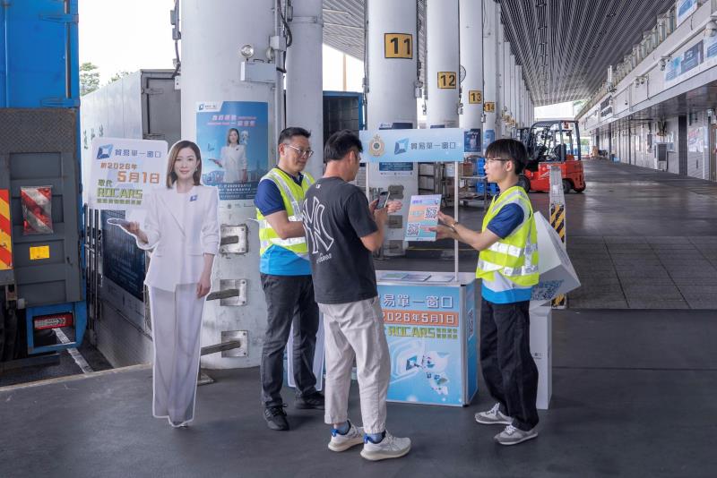 「貿易單一窗口」平台今日取代「道路貨物資料系統」，供業界提交道路預報貨物資料。海關人員於陸路邊境管制站協助跨境貨車司機過渡至「單一窗口」。（政府新聞處圖片）