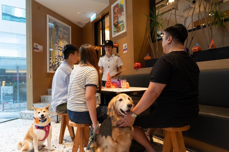 食環署人員到獲准食肆向攜狗顧客派發宣傳單張，提醒他們攜狗外出用膳時須守法依規。 (政府新聞處圖片)