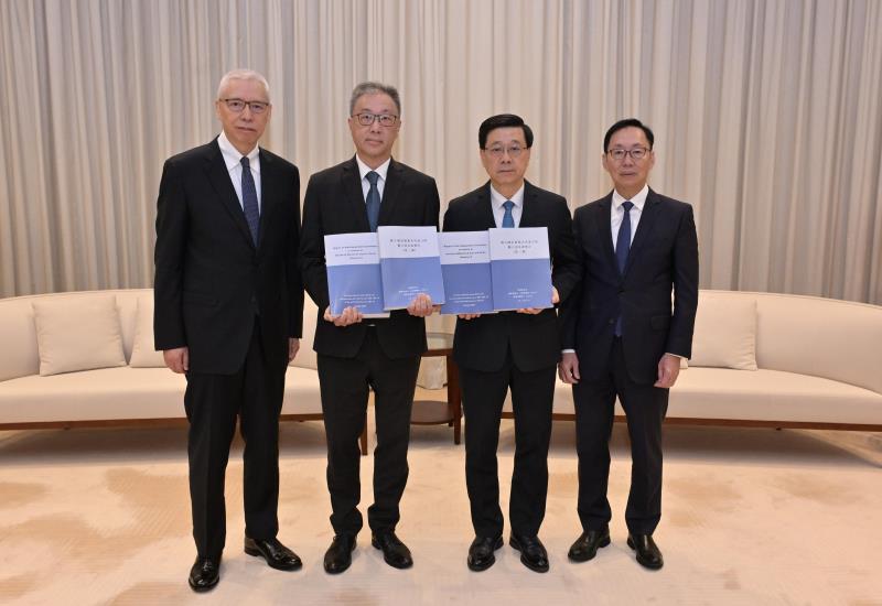 行政長官李家超（右二）今日收到就大埔宏福苑火災成立的獨立委員會主席陸啟康（左二）、委員陳健波（右一）及歐陽伯權（左一）呈交的報告。(政府新聞處圖片)